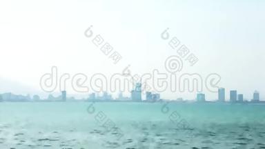 摩天大楼的轮廓在雾和海洋模糊的背景视频过渡。 薄雾笼罩着大海和城市摩天大楼